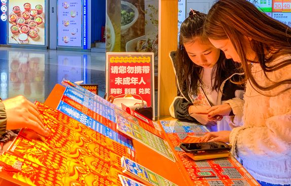 Young people buying scratch lotto tickets in Foshan