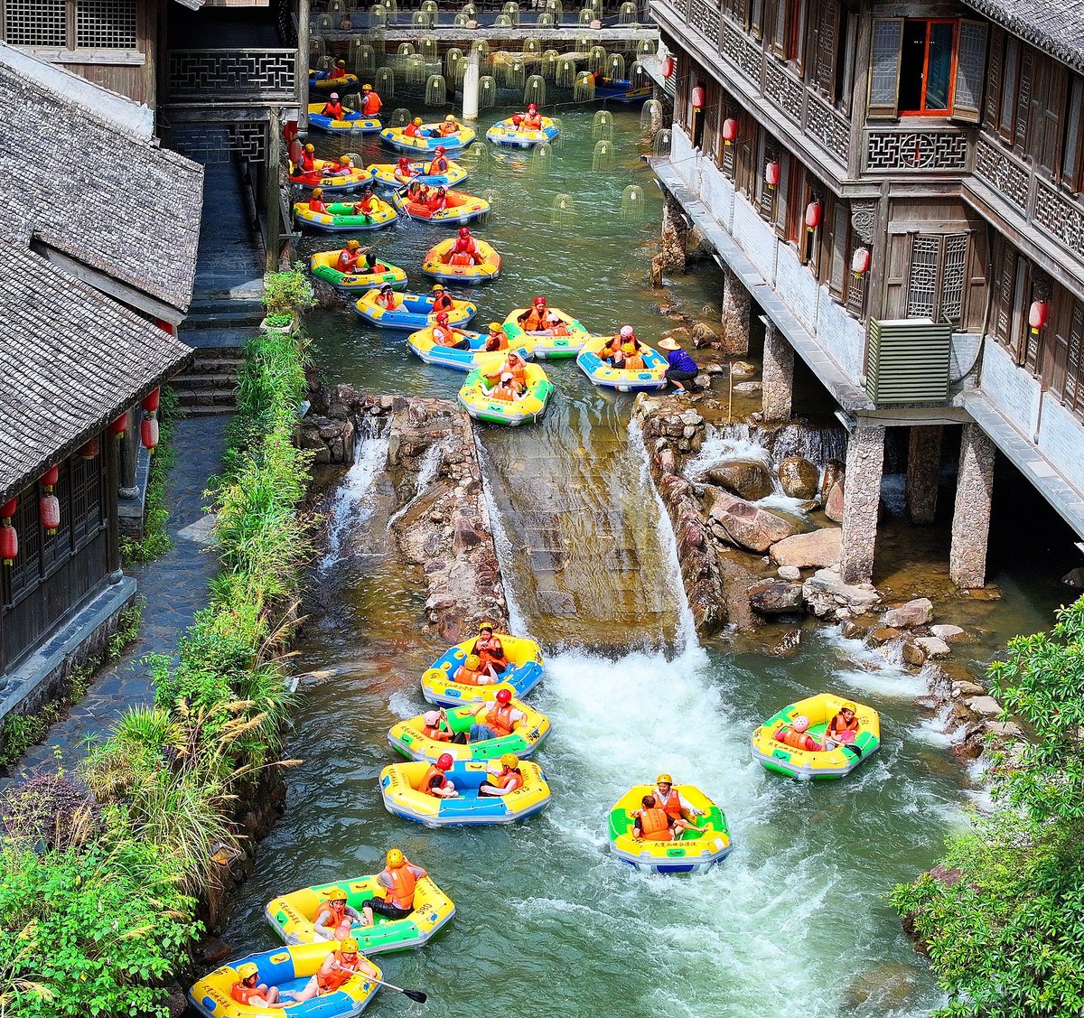 Visitors float down the river on inflatable rafts to cool off and enjoy the scenery at a rural rafting spot in Fuzhou