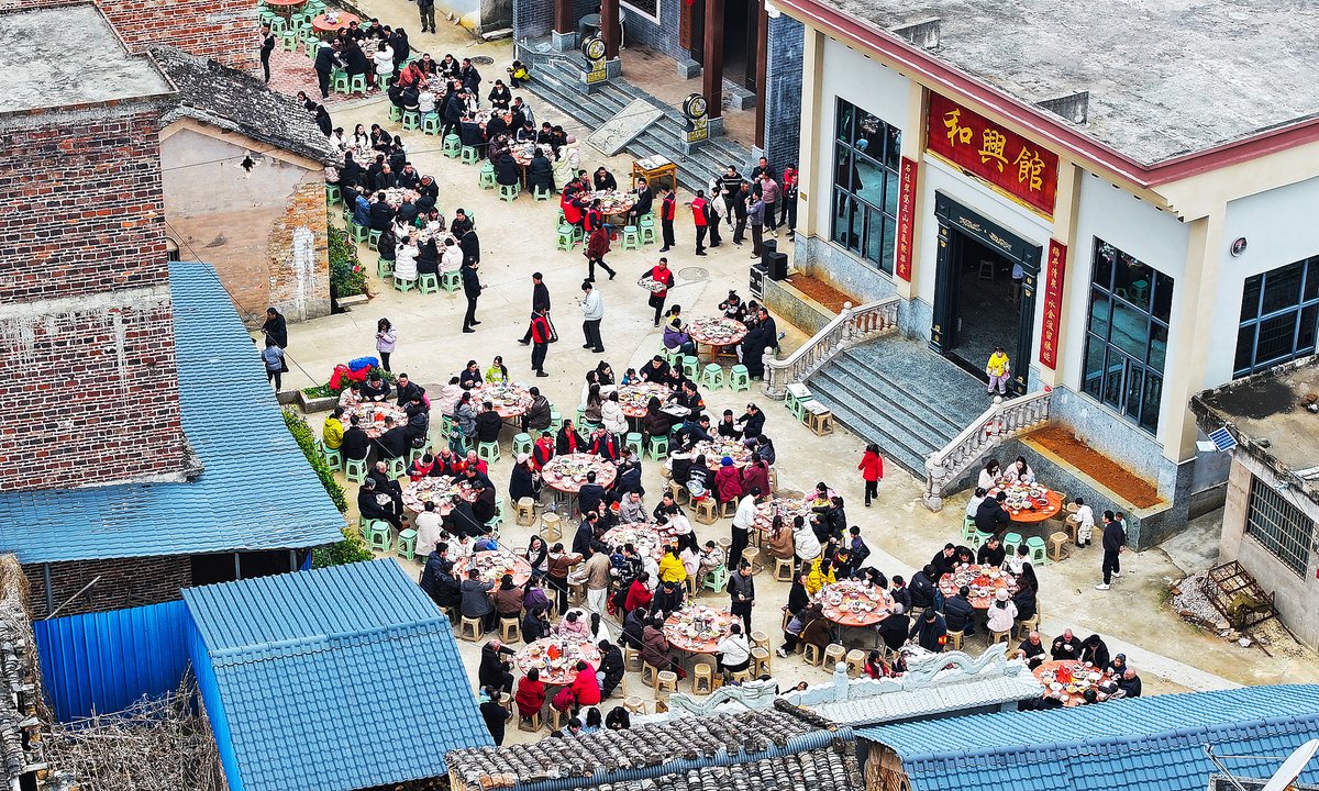 Tourists and villagers are enjoying a local New Year pig feast in Yongzhou, Hunan