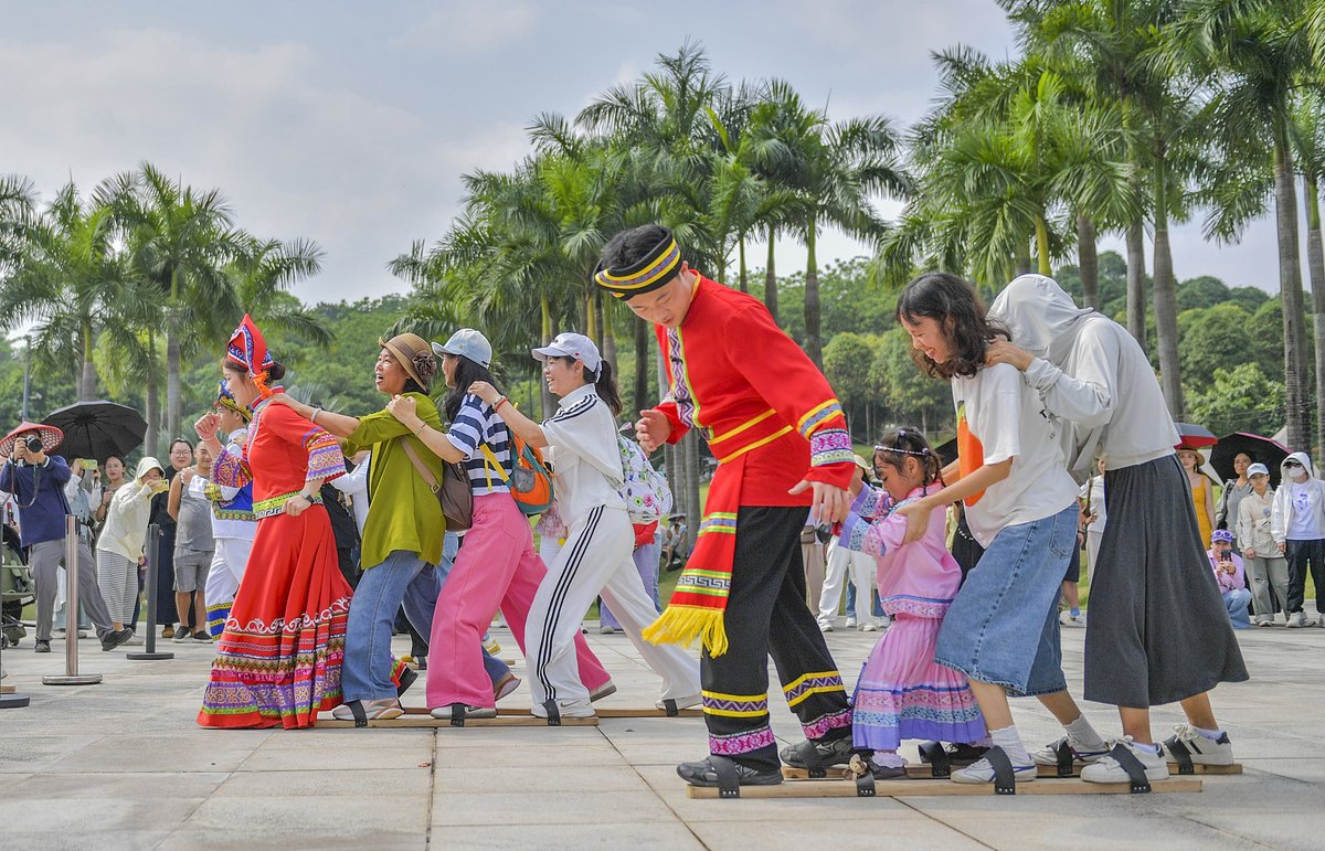 Visitors join a longboard shoe race, a traditional Zhuang ethnic sport, during this year’s Sanyuesan ethnic festival event in Nanning, Guangxi