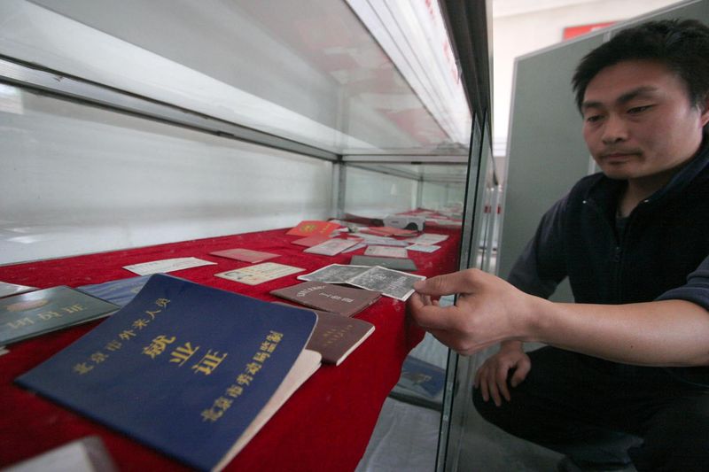 An exhibit of temporary work and residence permits from various cities in China on display at Picun's Worker Museum
