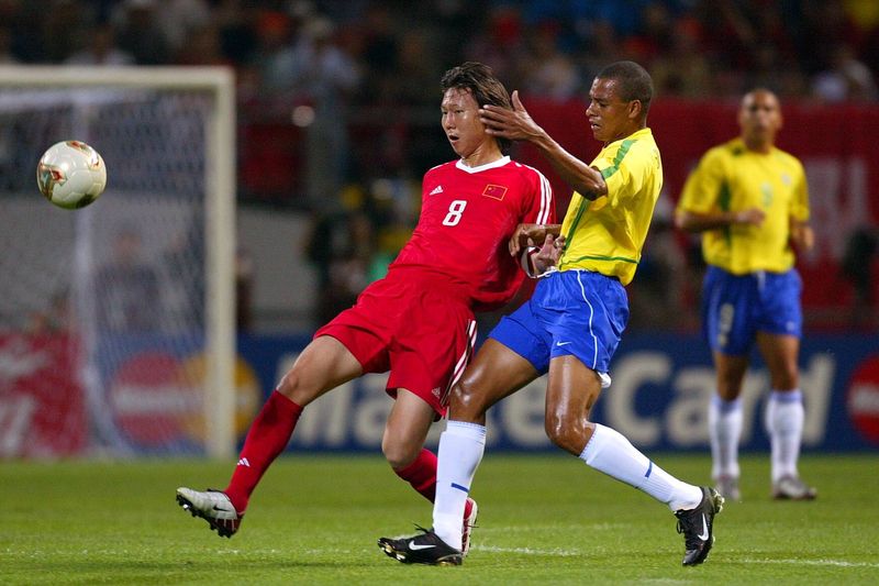 Chinese player Li Tie fights for the ball with Brazilian Gilberto Silva in their World Cup group match in 2002