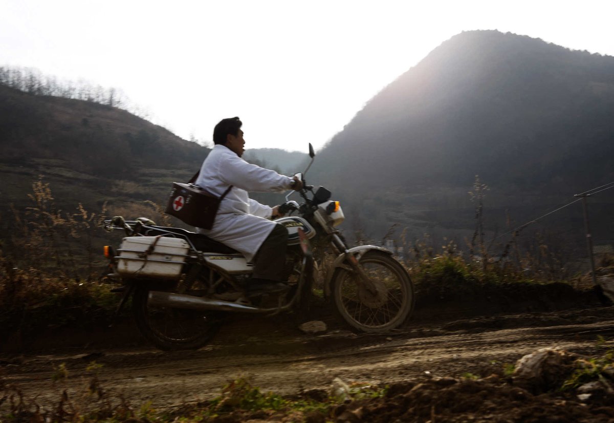 Chinese village physician Deng Wanxiang rides a motorcycle to make his house calls in Hubei province