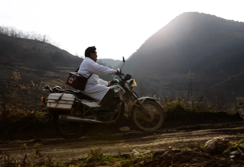 Chinese village physician Deng Wanxiang rides a motorcycle to make his house calls in Hubei province