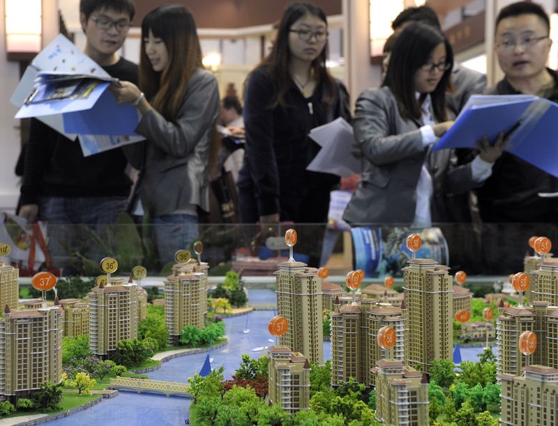 Chinese couples discussing new properties with salespeople, China's prenuptial agreements