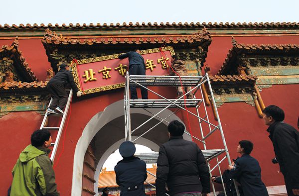 Workers remove the sign of the Beijing Youth Palace from Shouhuang Hall imperial temple in Jingshan Park in 2013, after 57 years&#x27; occupation