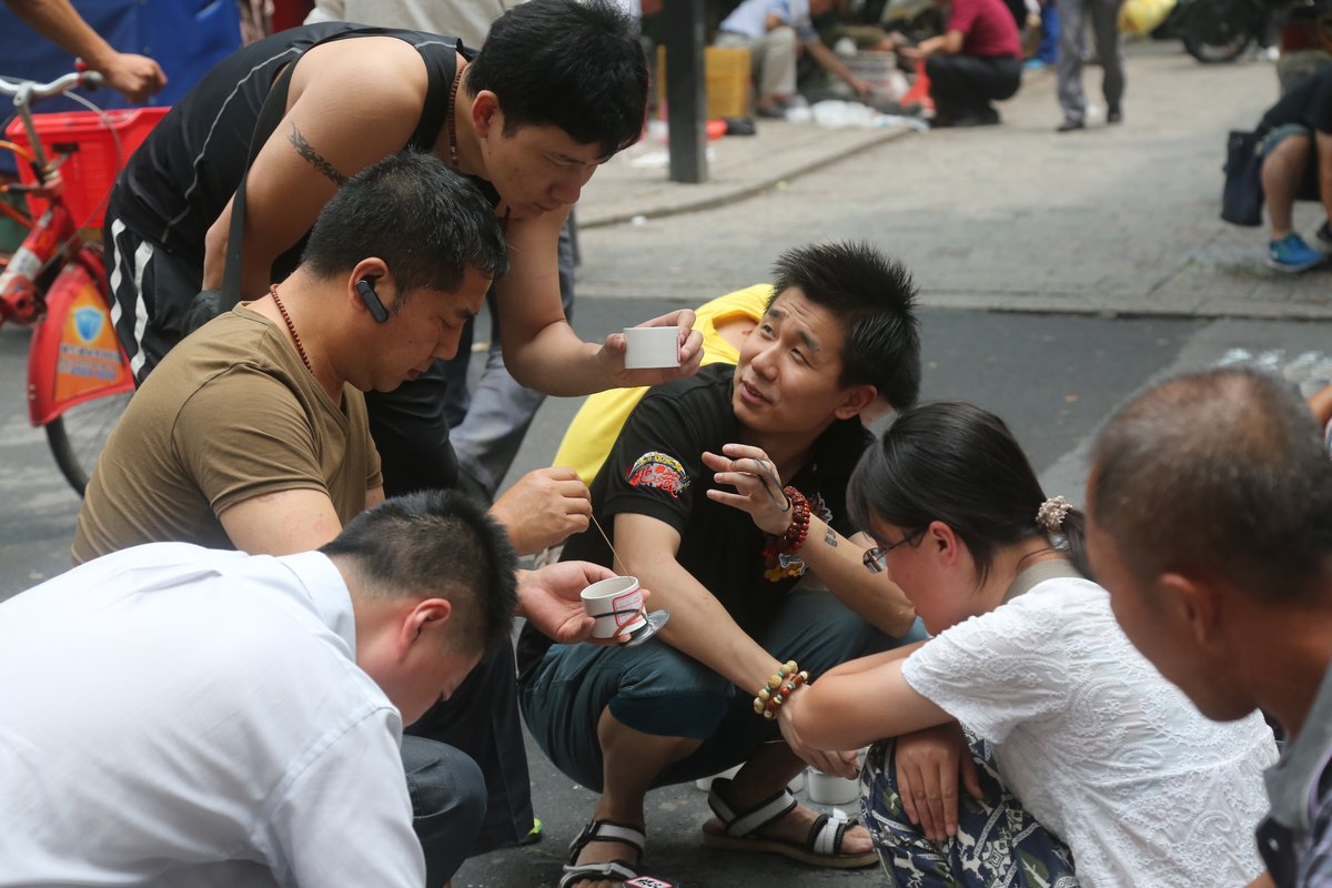 Chinese men catching crickets