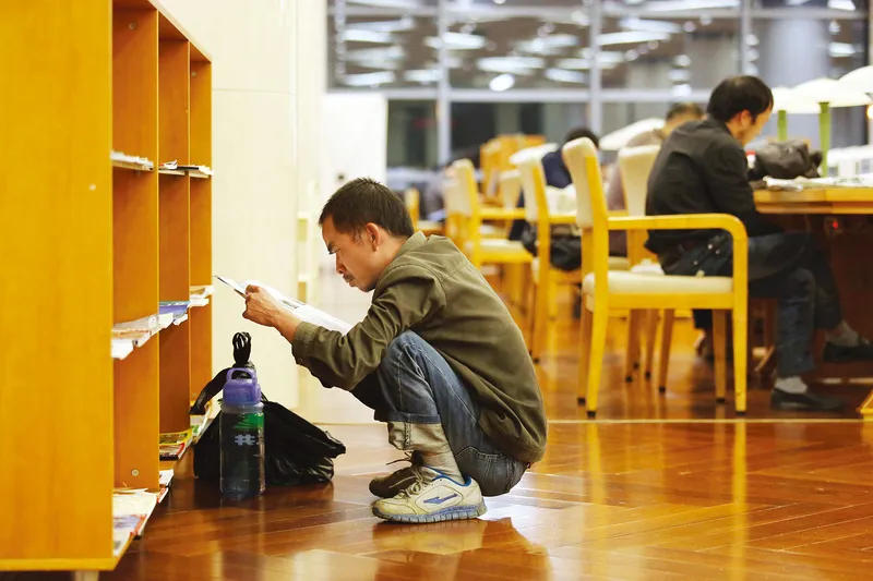 Wu Jun (pseudonym), a 30-year-old scrap collector from Anhui, reads books in the Hangzhou Public Library until closing every day