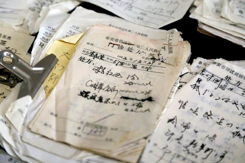 Stacks of old unpaid pharmacy bills, made out to Chinese village doctor Liu Jisheng in Shandong province
