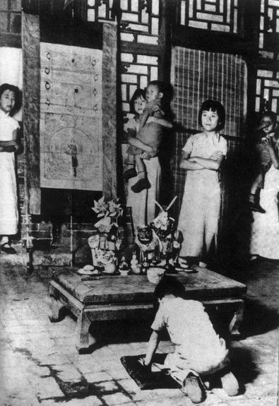 A child praying to Lord Rabbit, or 兔儿爷, in Beijing at Mid-Autumn Festival during the Republican Era (1912 – 1949). The ritual originated in the Ming dynasty, with a legend of a rabbit on the moon that