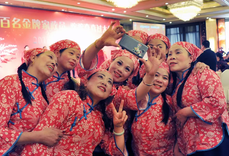 Nannies and housekeepers perform at a Lunar New Year banquet organized for housekeeping industry workers in Shanghai in 2016