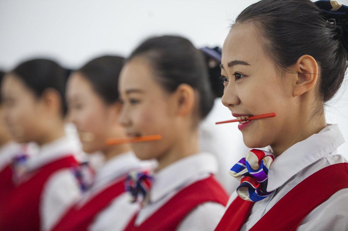A teacher in Changchun, Jilin instructs students to practice smiling with chopsticks