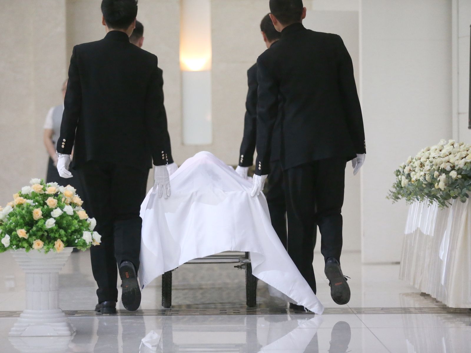 Funeral workers transporting body