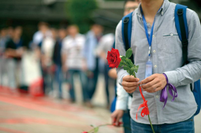 A participant holds a rose while attending a speed-dating event, with Shanghai’s elite speed dating being amongst the most popular