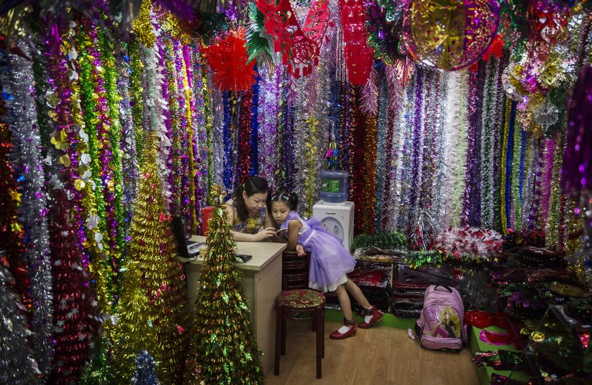Shopkeepers at Christmas stall at Yiwu Trade Fair, China