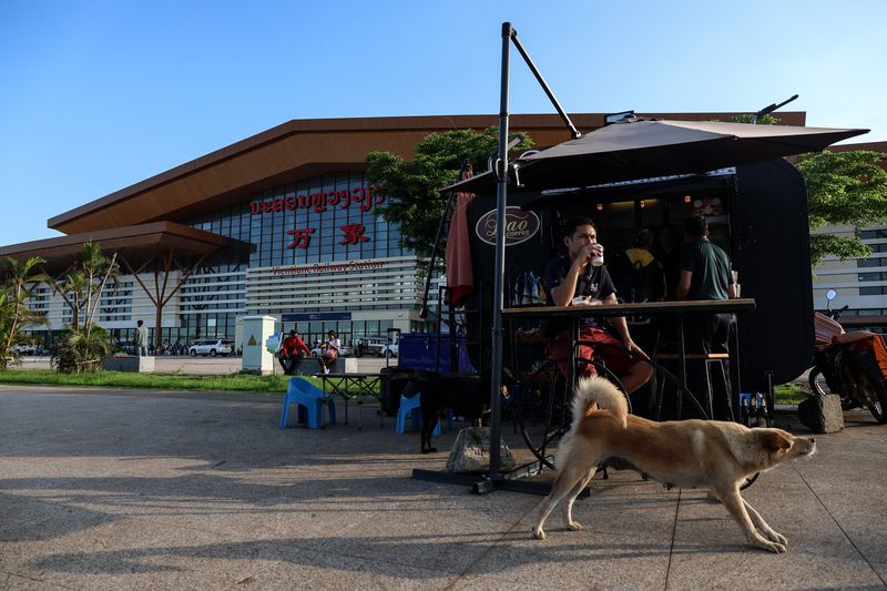 A mobile cafe in front of the Vientiane, Laos train station waits for customers to arrive, as customers arrive from the laos-china railway