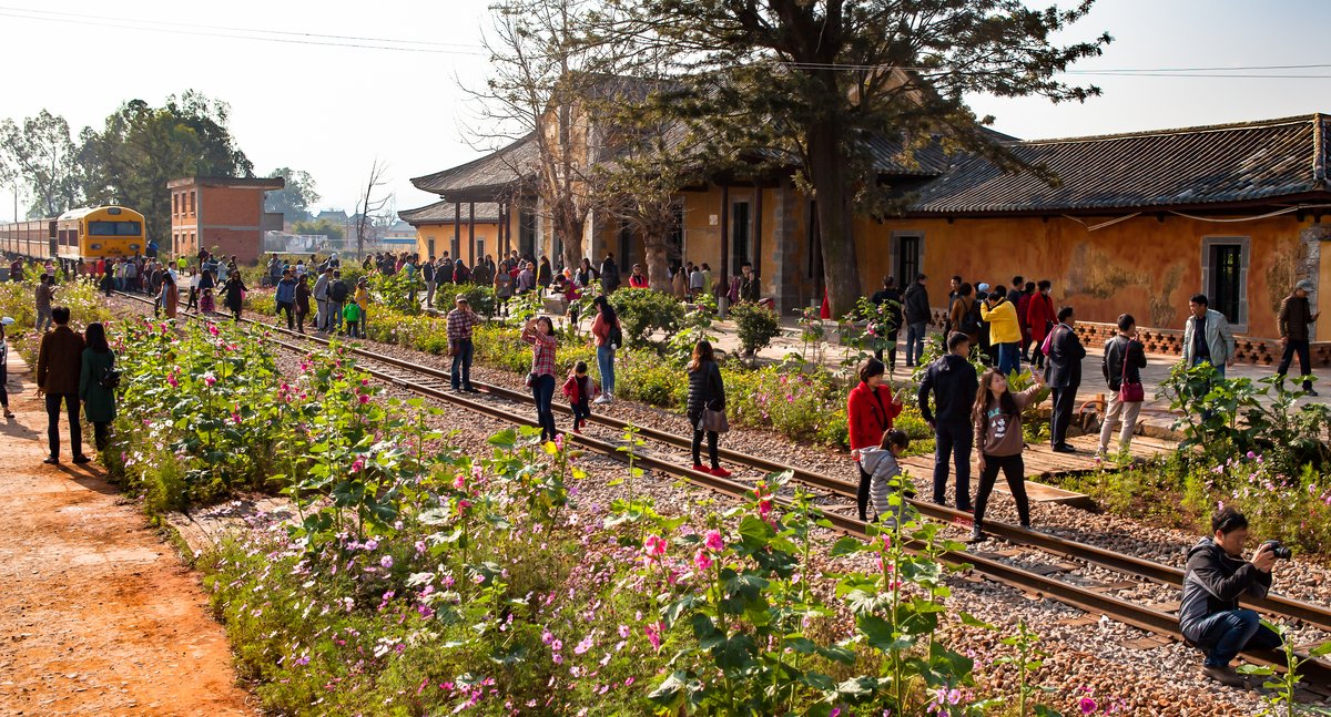 Tourists on the tracks in the sunshine at Jianshui station