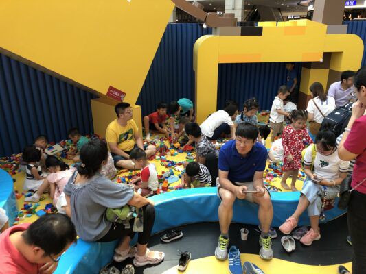 Children and parents playing with legos at the Lego Experience Center. 