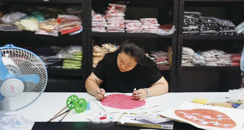 Zheng designing hanfu patterns in her studio