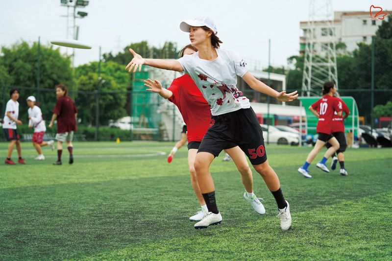 Wu Xiaohua throwing a frisbee as her all-women’s team competes with a mixed team in a match