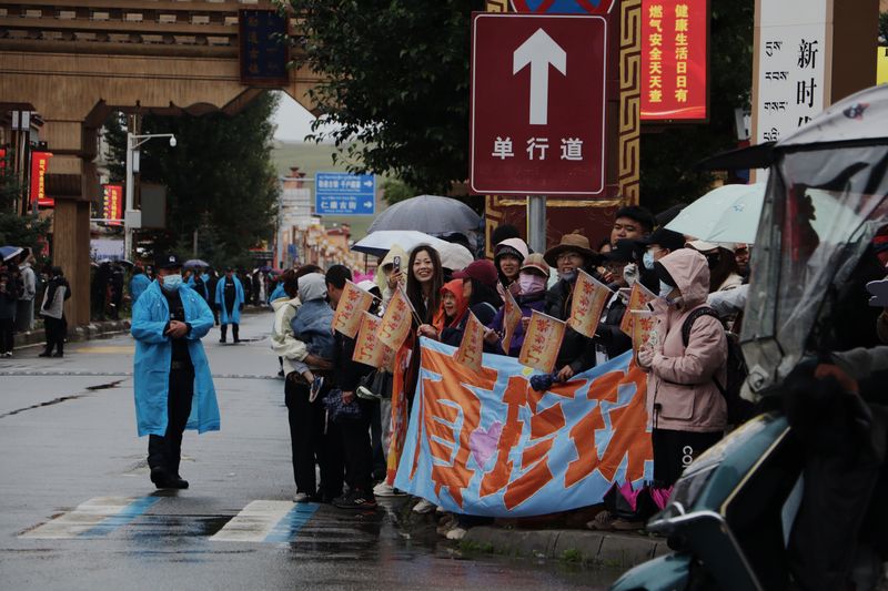 Fans of Ding Zhen hold flags and banners of his name