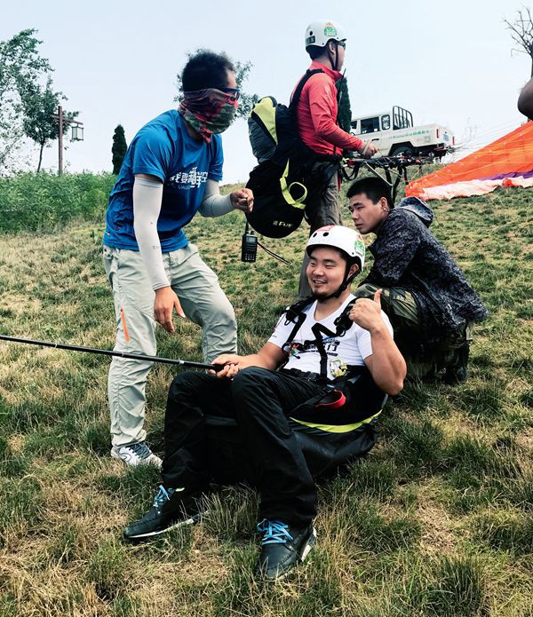 Organizers in Henan help a disabled athlete attempt to paraglide. 