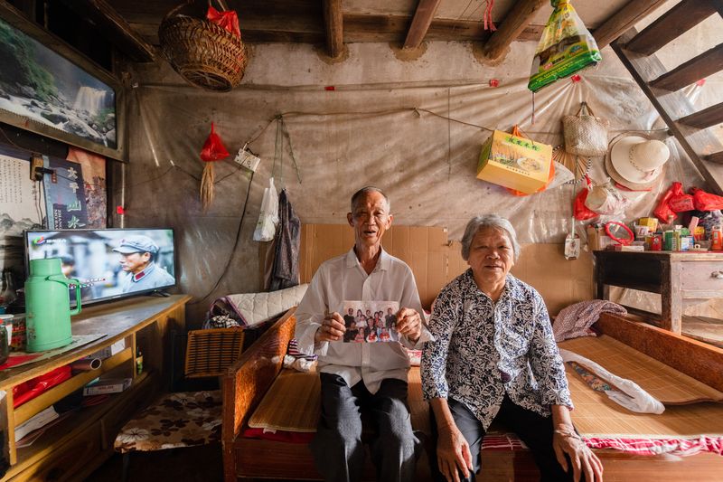 Jichang and his wife with a photo of relatives who used to live in Xinyunlou