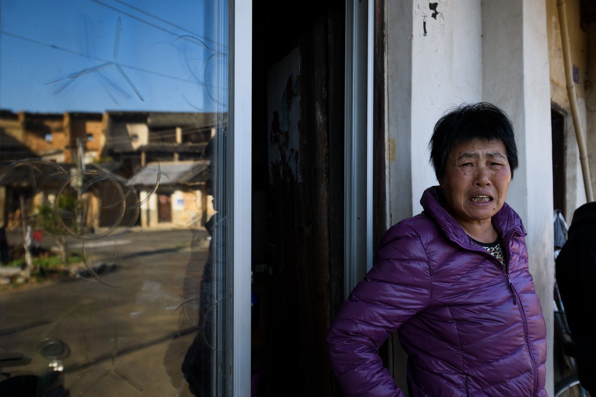 Mrs. Huang outside her tulou home