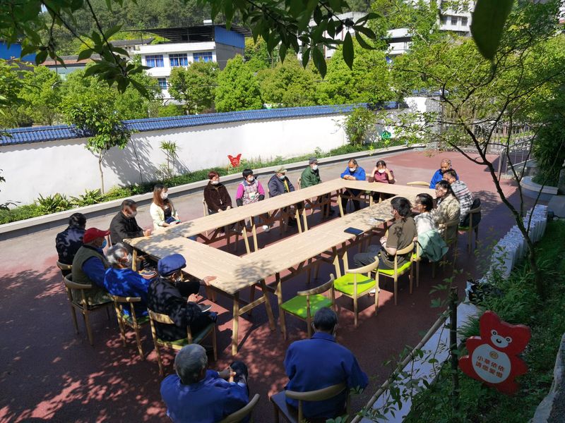 At a Tongyue facility, Liu Yi, young interns, older caregivers, and elderly residents sit together to discuss the matters related to the center