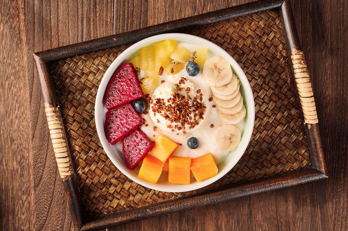 A bowl of yogurt with a mixture of fruits