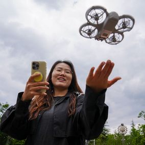 Young Chinese woman flying rental drone