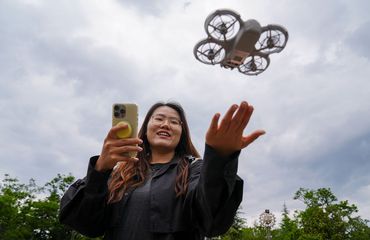 Young Chinese woman flying rental drone