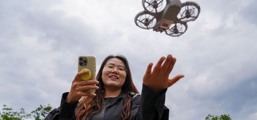 Young Chinese woman flying rental drone