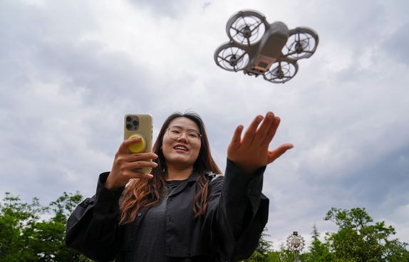 Young Chinese woman flying rental drone