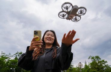 Young Chinese woman flying rental drone