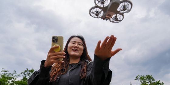 Young Chinese woman flying rental drone