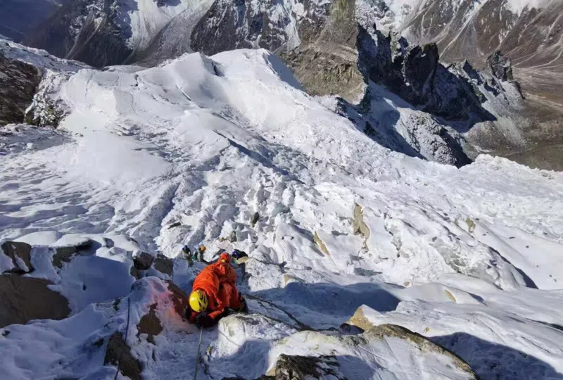 Zhang Hong scaling the side of a mountain cliff