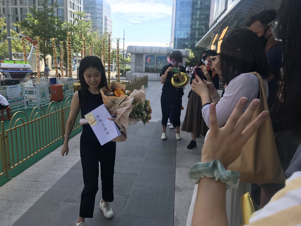 Xianzi makes her way to the court as supporters and media look on