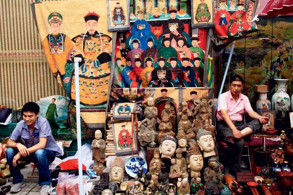 Two merchants sell their dubious wares in the famous Panjiayuan antique market in Beijing