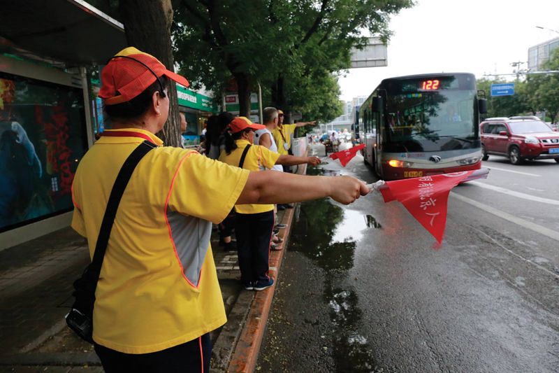 Yellow-shirted volunteers who direct bus traffic are known as "civilization guides"