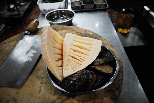 Immerse the dried mushrooms in water overnight to soften them. Drain and cut off their roots. Peel the bamboo shoots, cut it open and wash thoroughly.