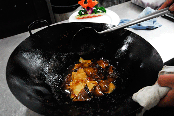 Pour the sauce around the ingredients in the wok, stir until even. The sauce of the dish should now be thicker. Heat for a few more seconds and the dish should be ready to serve.