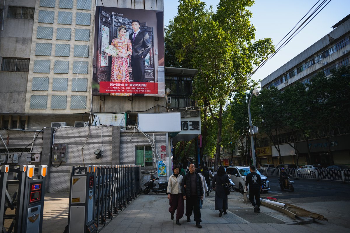 Pedestrians in Chaozhou, Guangdong province walk past a large ad for Pretty Lady