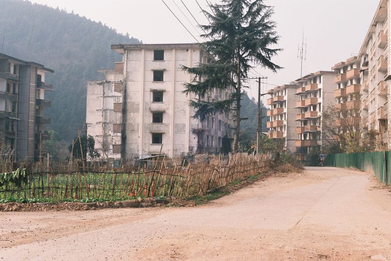 Former factory workers remain and use the old residential compound for farming, Yi ethnicity artist in china