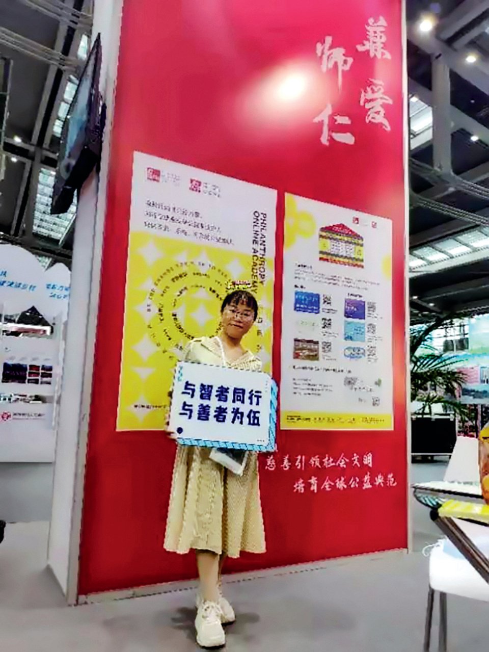 Tong Can, one among many inspiring and disabled Chinese women holds up a small sign at an event.