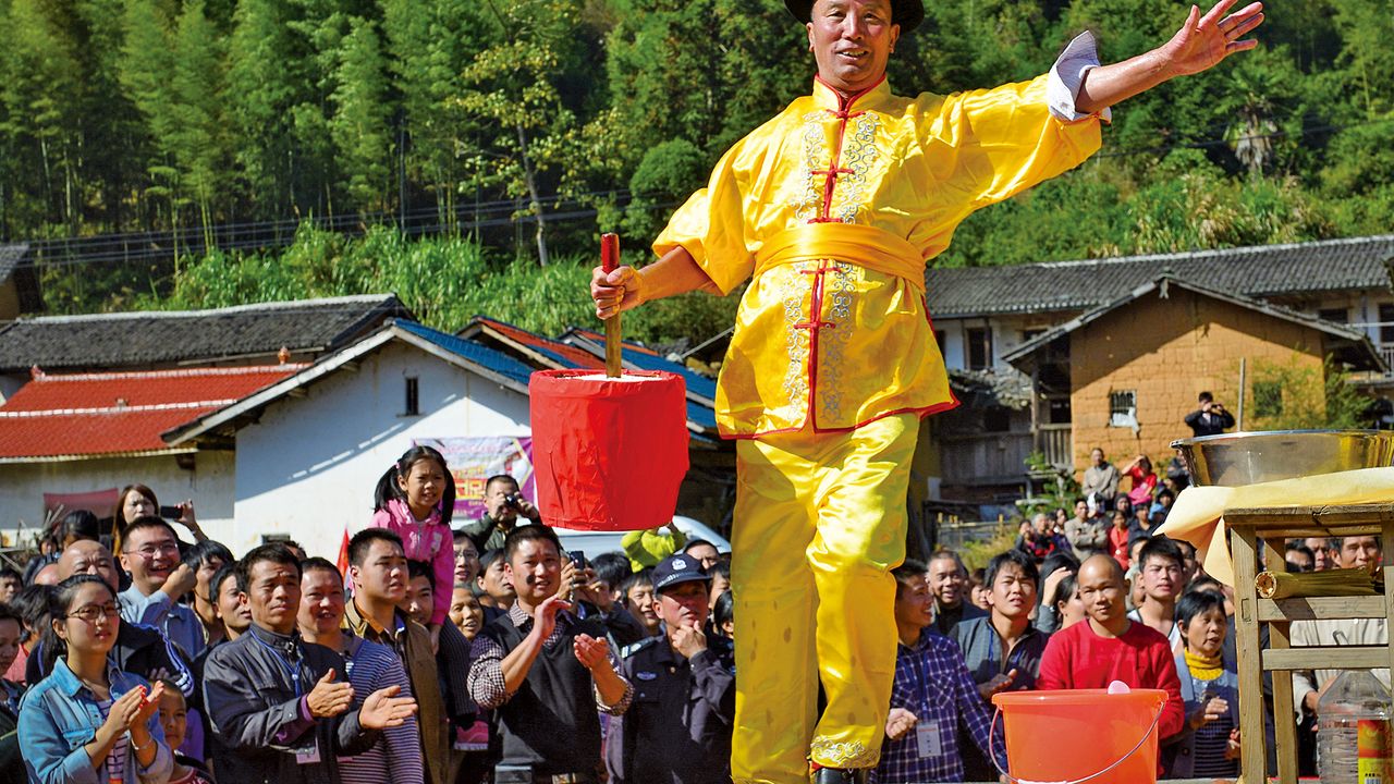 In “lifting the rice bucket,” the performer lifts up a container of rice, using a sharp sword inserted in the middle as a handle
