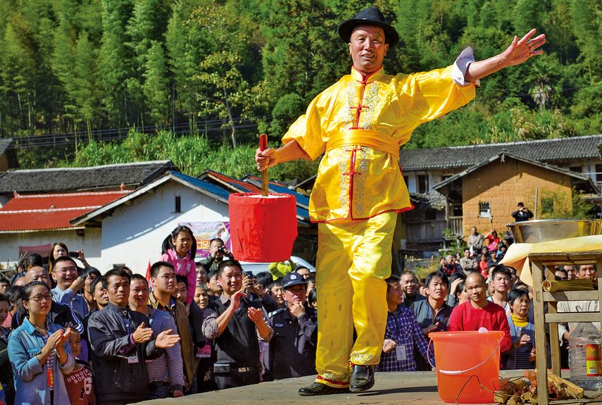 In “lifting the rice bucket,” the performer lifts up a container of rice, using a sharp sword inserted in the middle as a handle