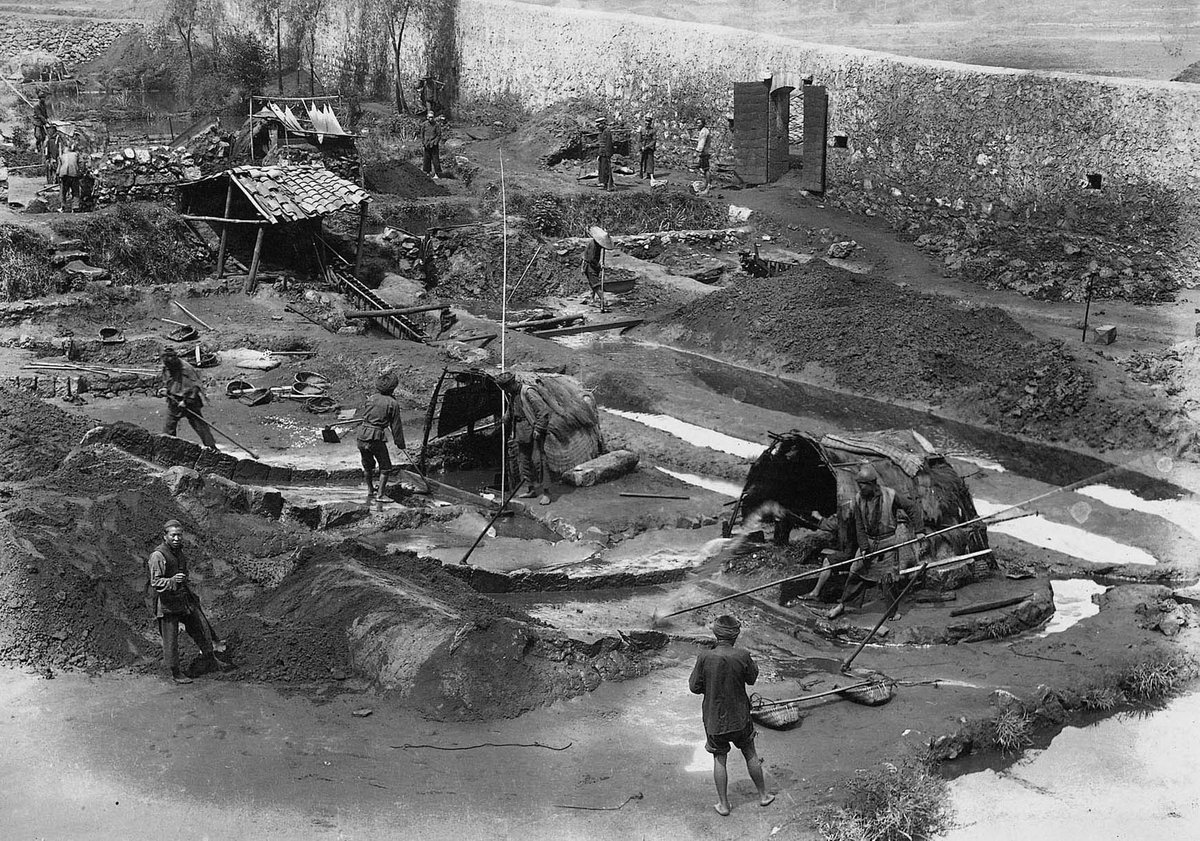 Miners using a trough-washing method to clean through tin ore at a mining site in Gejiu during the Republican Period