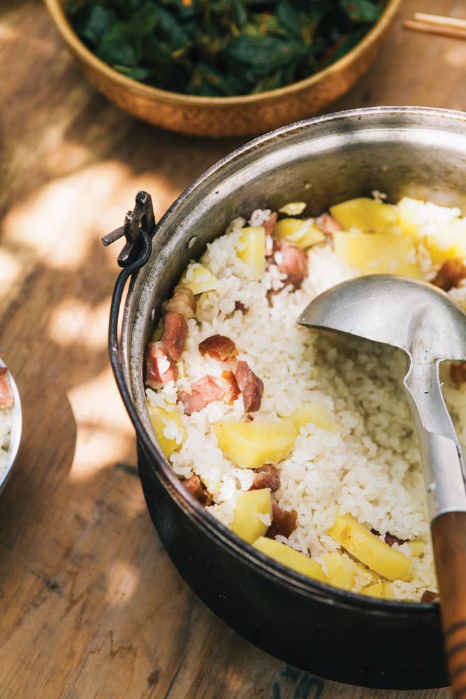 Dali locals cook ham together with rice and potatoes in a pot over the fire