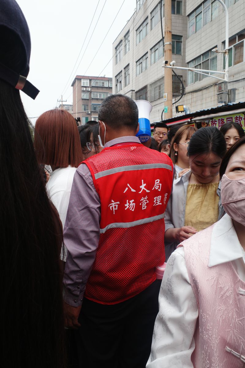 Crowd control personell managing people in Ziob, Shandong